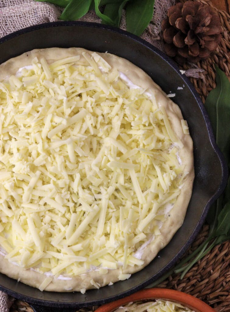 image of how to top the pizza with cheddar cheese